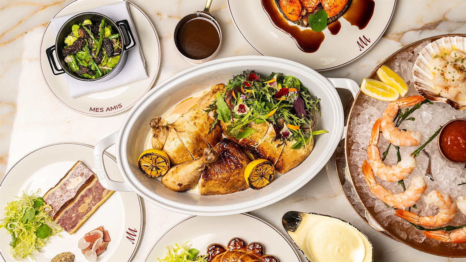 A selection of dishes served as Mes Amis including a shellfish tower, a platter of whole-roasted chicken with seasonal vegetable, sides and more